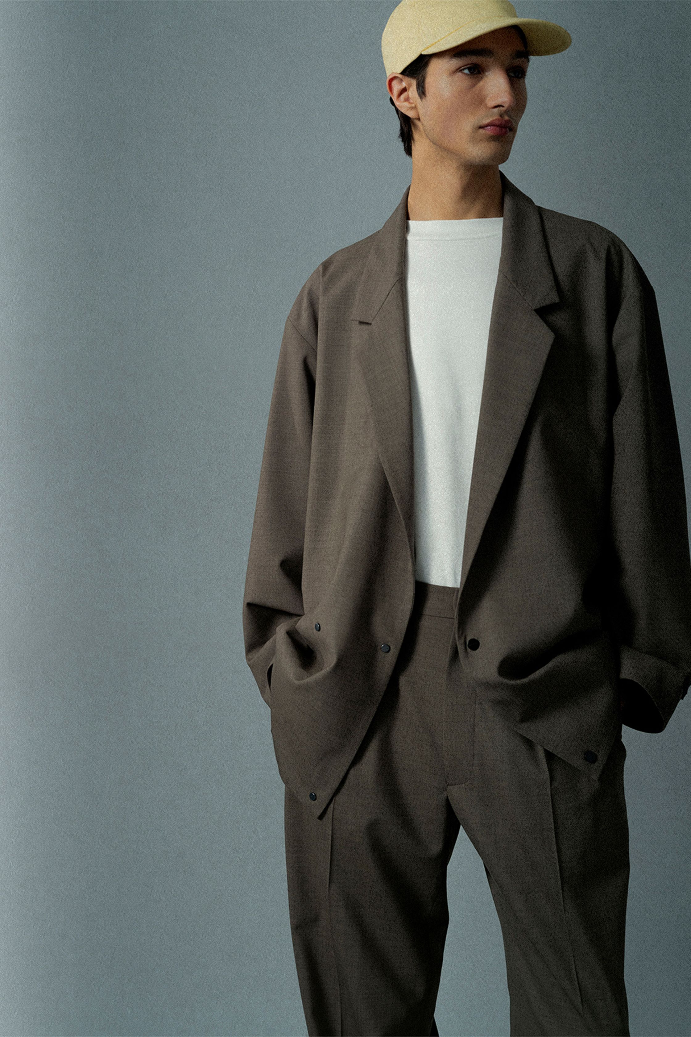 Fear of God 2026秋冬继续深化品牌标志性的极简街头美学：宽松西装、结构大衣、长裤与中性色调构建出安静而克制的现代衣橱。沙色、灰色与深黑形成柔和色谱，大廓形比例让服装在身体周围形成自然空间。设计师通过极简设计语言将街头文化提升至高级时装层面，使系列既具有精神性，也兼具实穿功能-顽石频道趋势研究